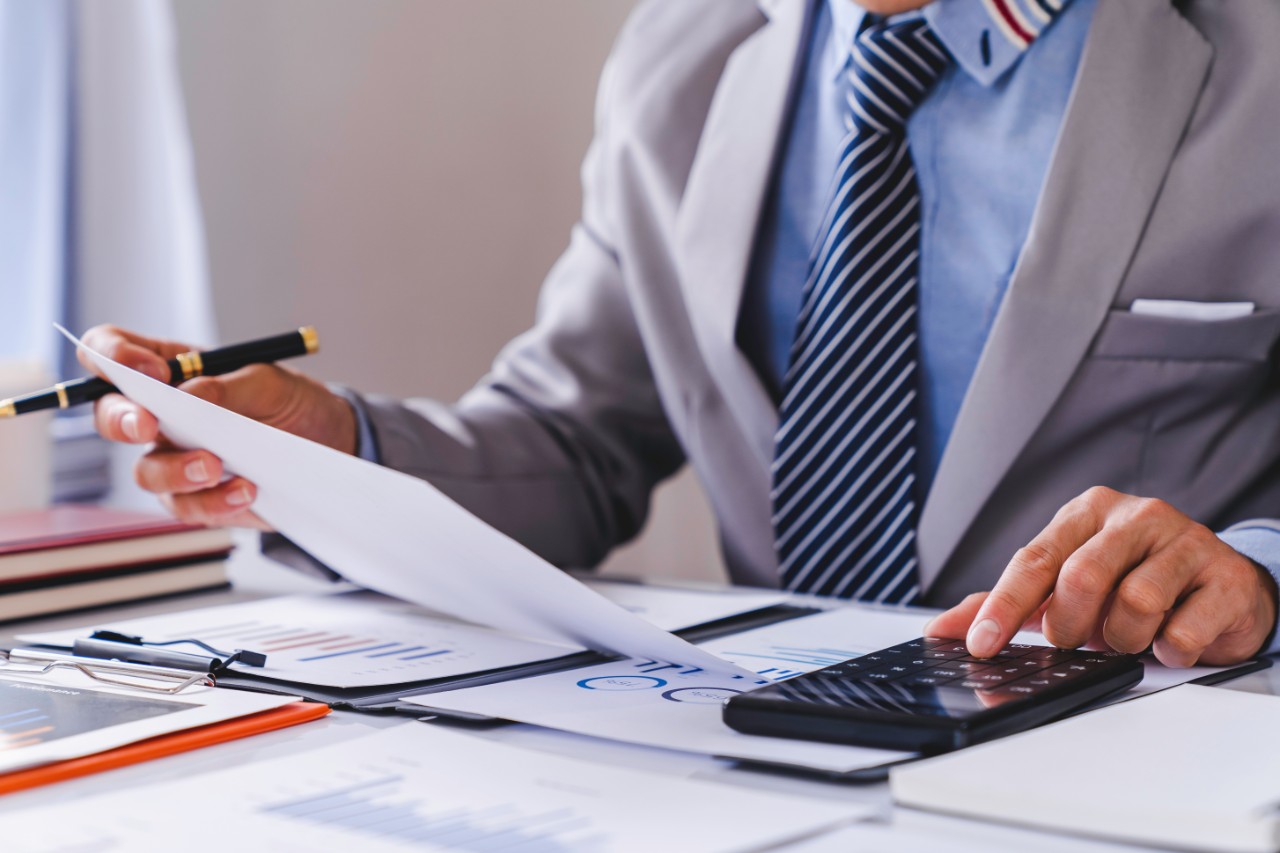 Man looking at information on a sheet and using a calculator